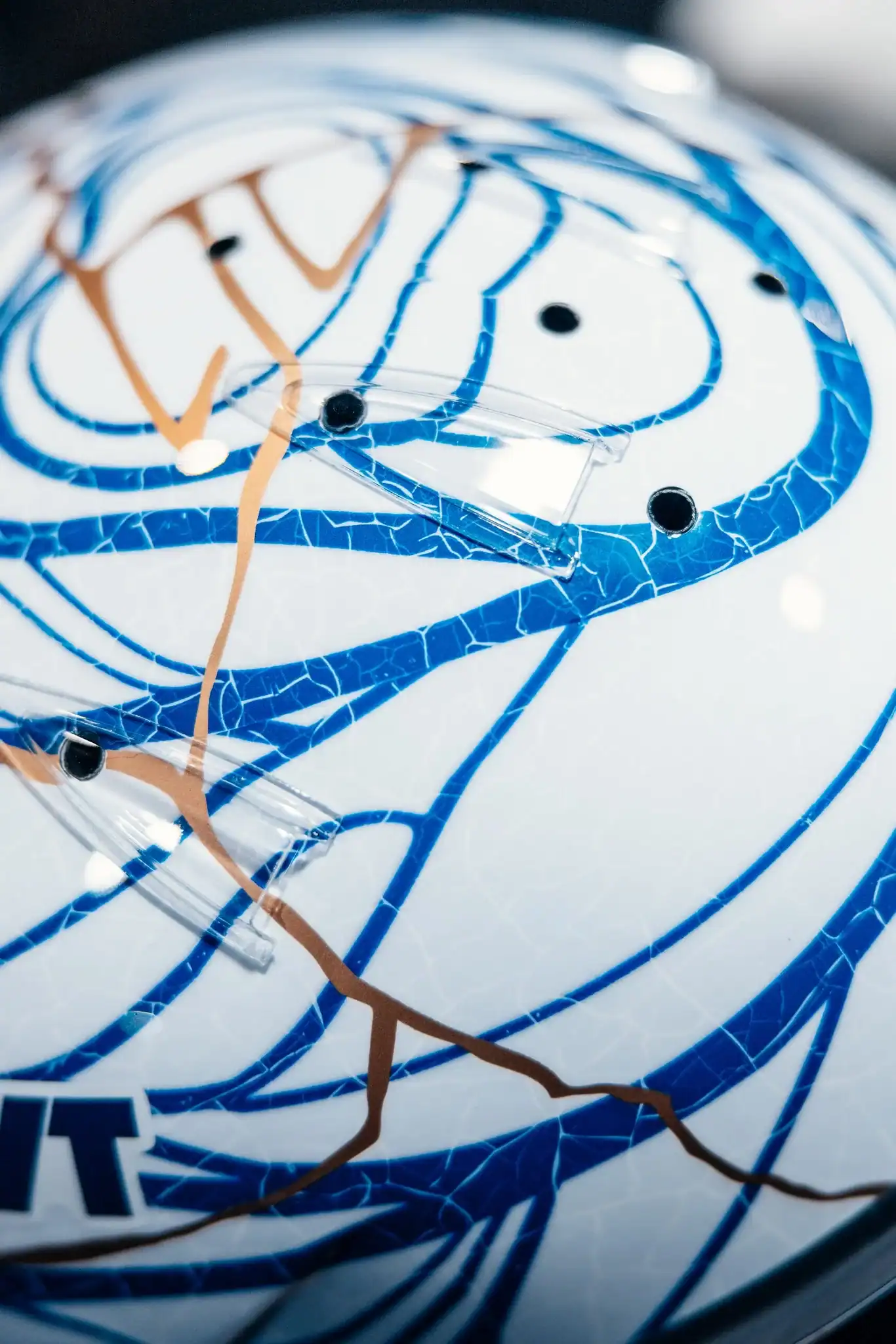 Nahaufnahme von Pierre Gaslys Japan-GP-2026-Helm mit goldenen Kintsugi-Reparaturadern und blauen Rissmustern auf wei&szlig;er Porzellanbasis