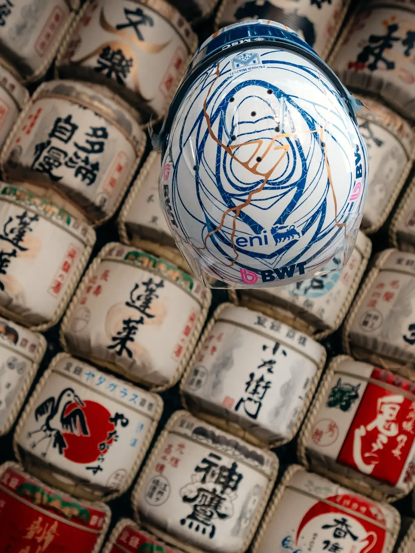 Pierre Gaslys Kintsugi-Helm vor traditionellen japanischen Sake-F&auml;ssern in Suzuka fotografiert &mdash; Draufsicht mit blauem flie&szlig;endem Design und goldenen Adern