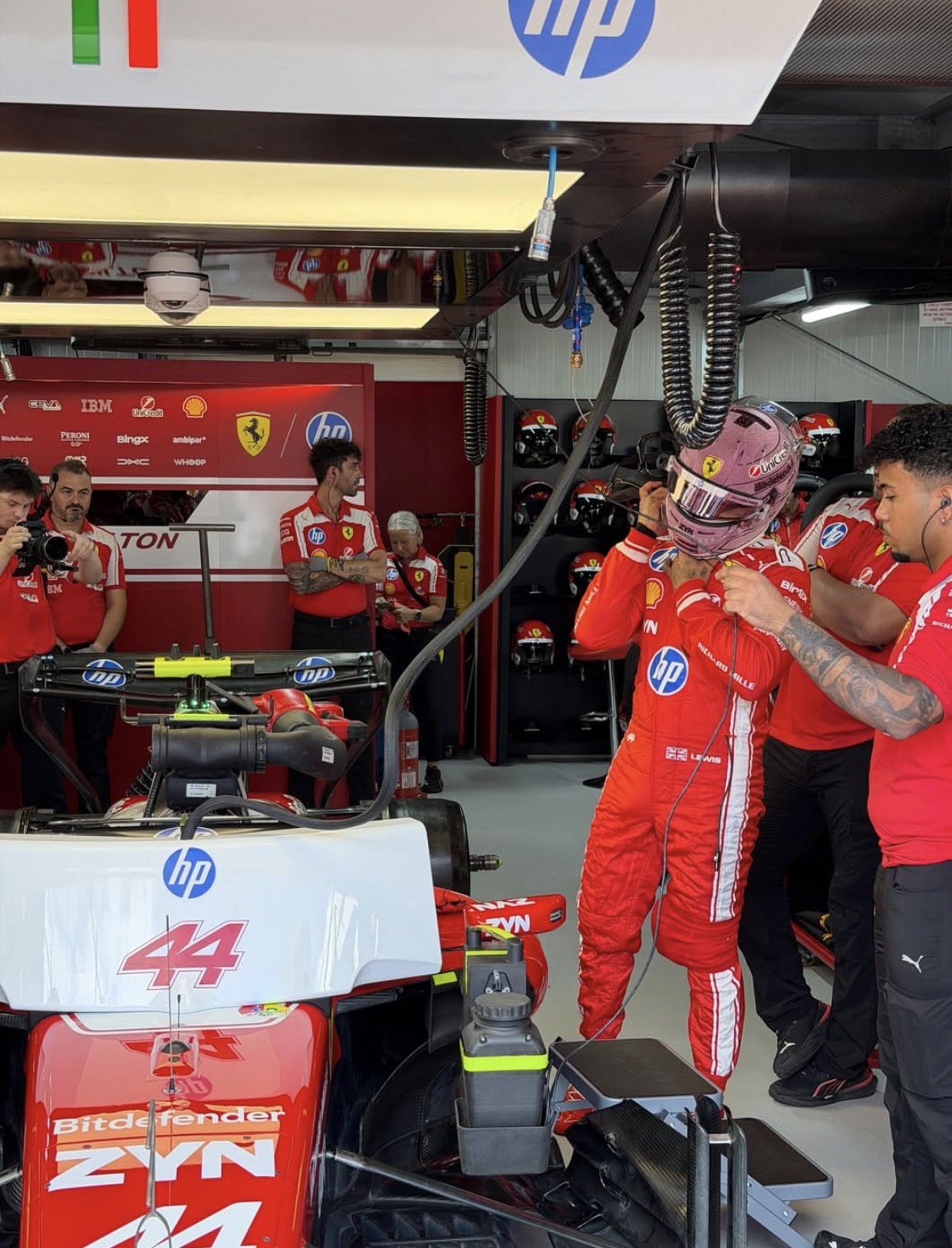 Lewis Hamilton with his pink crystal helmet in the Ferrari garage at the 2026 Monaco Grand Prix