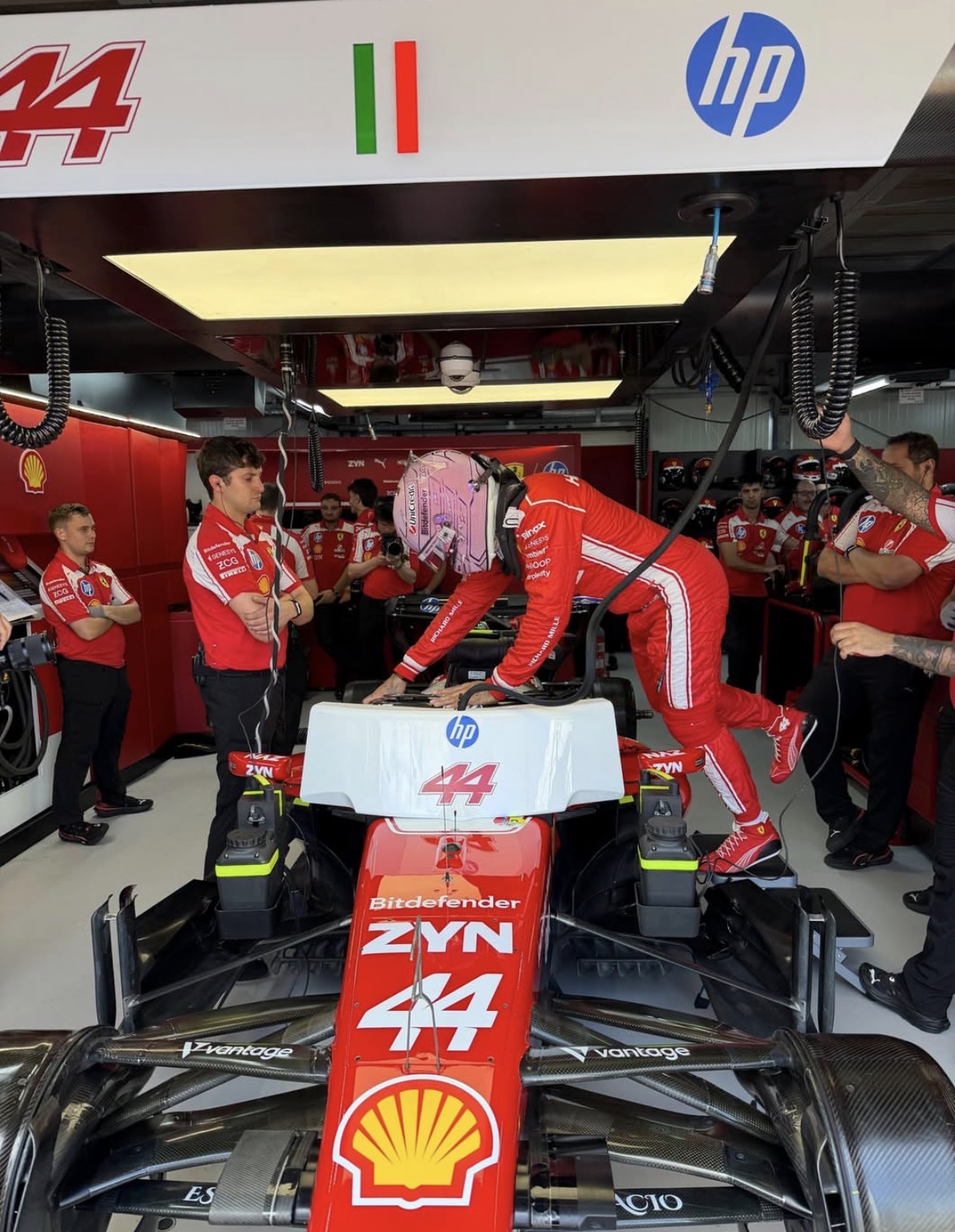 Primer plano del acabado de cristal brillante en el casco rosa de Lewis Hamilton de Mónaco 2026, marca de Perplexity en la parte trasera