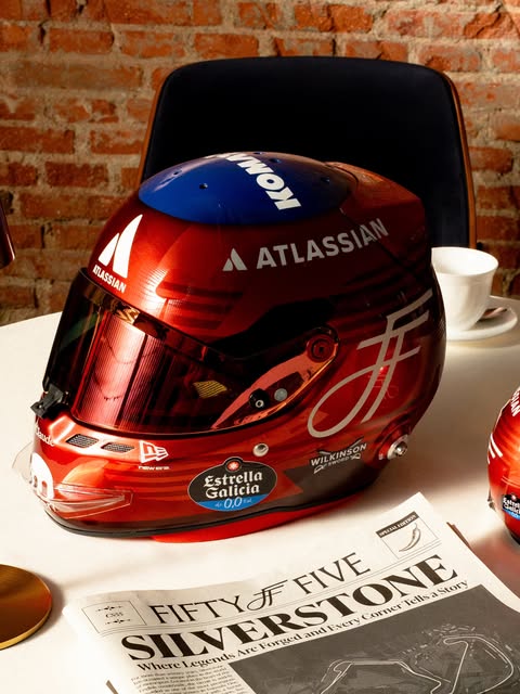 Carlos Sainz 2026 British GP helmet — candy-red shell with navy crown, silver Fifty Five monogram and Atlassian branding, side profile