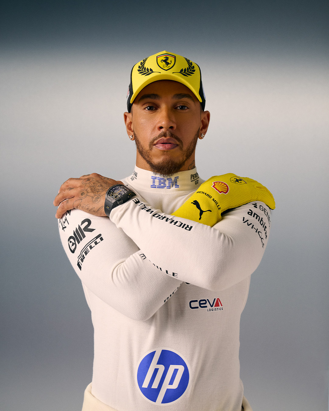 Lewis Hamilton wearing a yellow Ferrari cap and a yellow racing glove over his white base layer for the 2026 British Grand Prix.