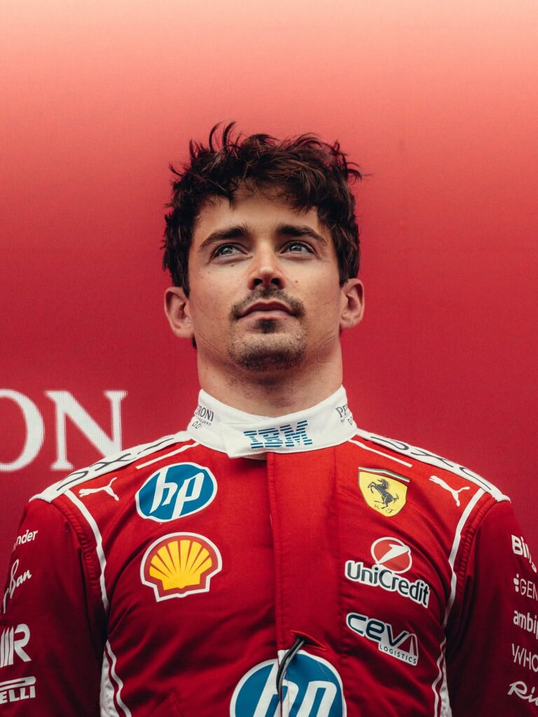 Charles Leclerc's Ferrari display replica helmet in red with team livery, close-up view.