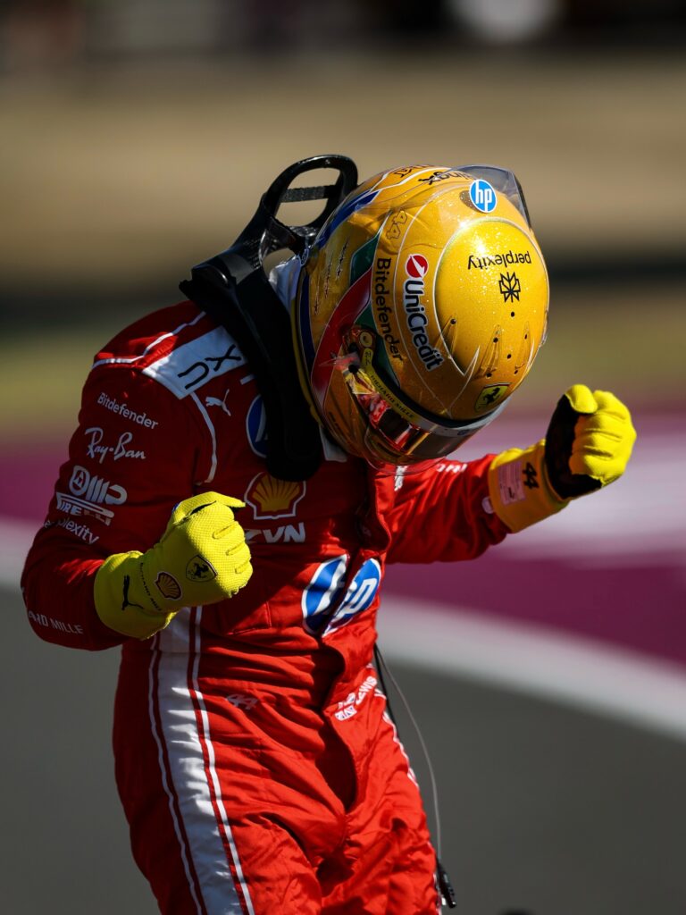 Lewis Hamilton celebrates sprint pole at the 2026 British Grand Prix at Silverstone, holding his gold number 44 Ferrari helmet