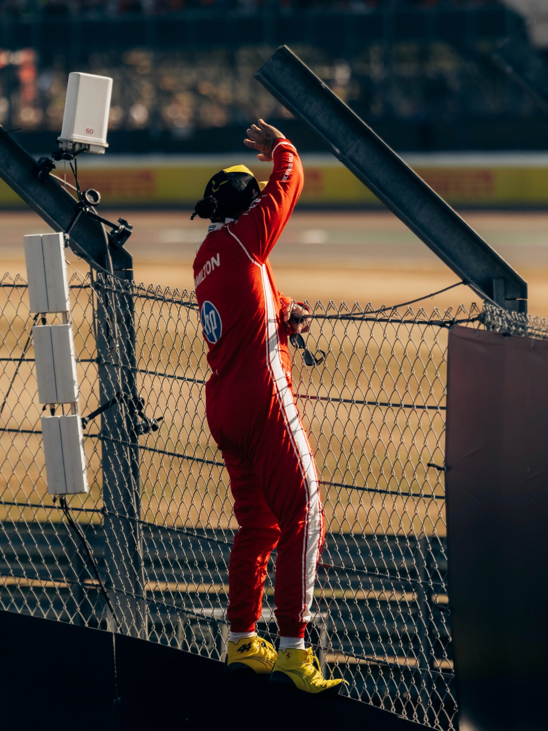 Lewis Hamilton climbs the fence to greet fans at Silverstone after topping sprint qualifying for Ferrari, 2026 British Grand Prix