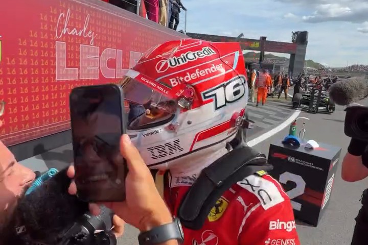 Charles Leclerc in parc fermé with his red #16 Ferrari helmet after winning the 2026 British Grand Prix at Silverstone