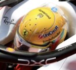 Top view of Lewis Hamilton's metallic yellow 2026 Silverstone helmet in the Ferrari cockpit, with Perplexity and HP on the crown