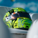 Side view of Lando Norris's fluoro-green Silverstone helmet with chrome blob swirls and a black sponsor band.