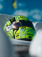 Side view of Lando Norris's fluoro-green Silverstone helmet with chrome blob swirls and a black sponsor band.
