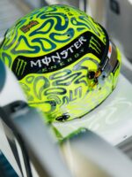 Rear view of Lando Norris's Silverstone helmet showing the chrome number and Monster Energy band over the fluoro-green base.