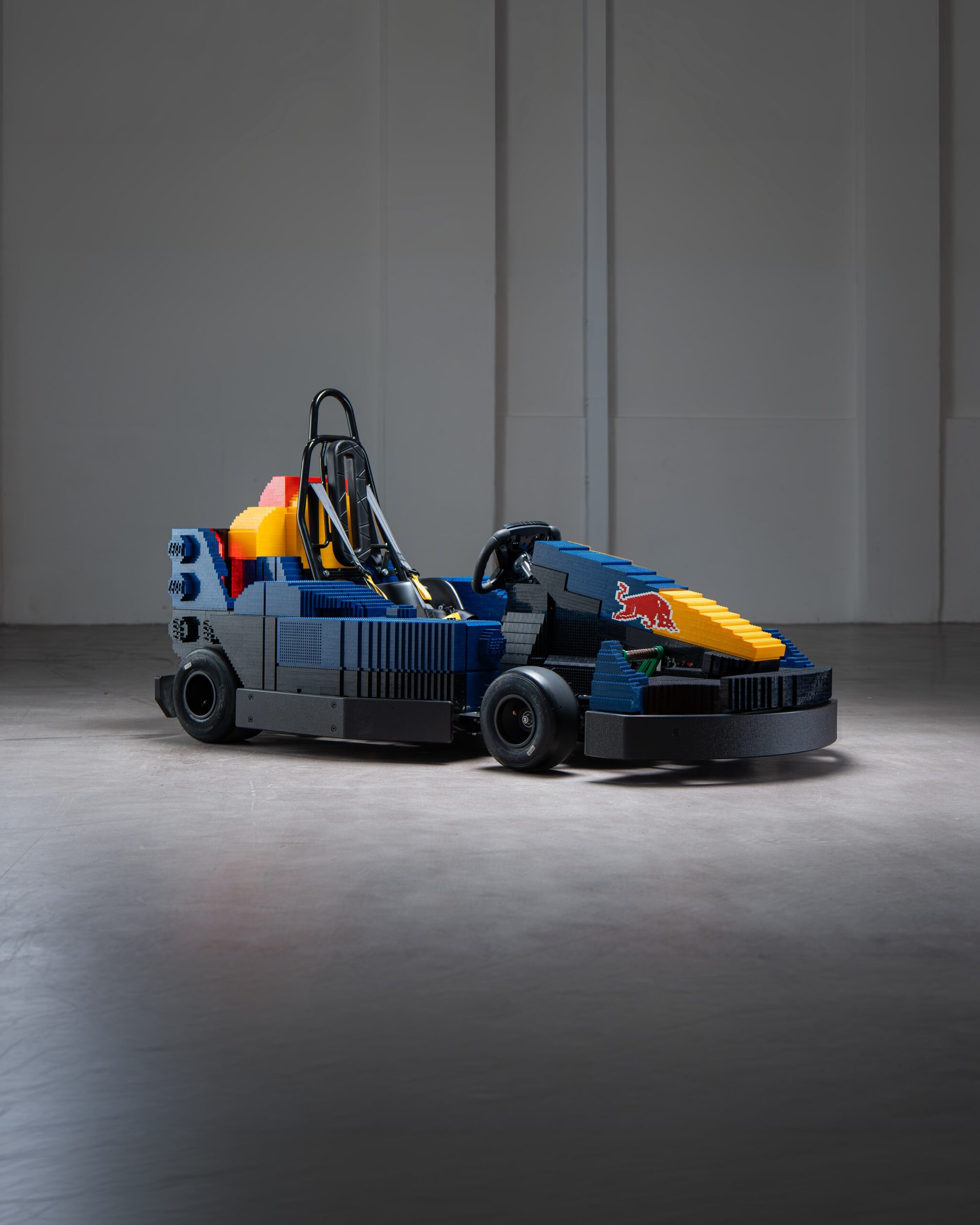 The Oracle Red Bull Racing RBrick1 LEGO kart in navy livery with a yellow nose and brick-built bull logo.