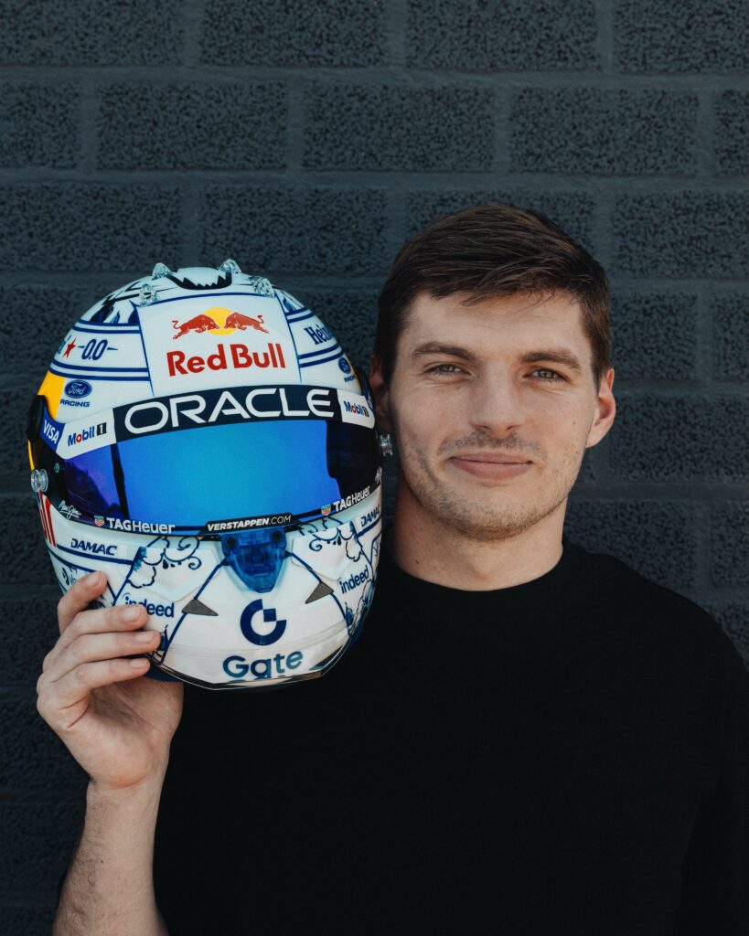 Max Verstappen holding his 2026 Zandvoort helmet, the Delft blue painted side panel facing the camera.