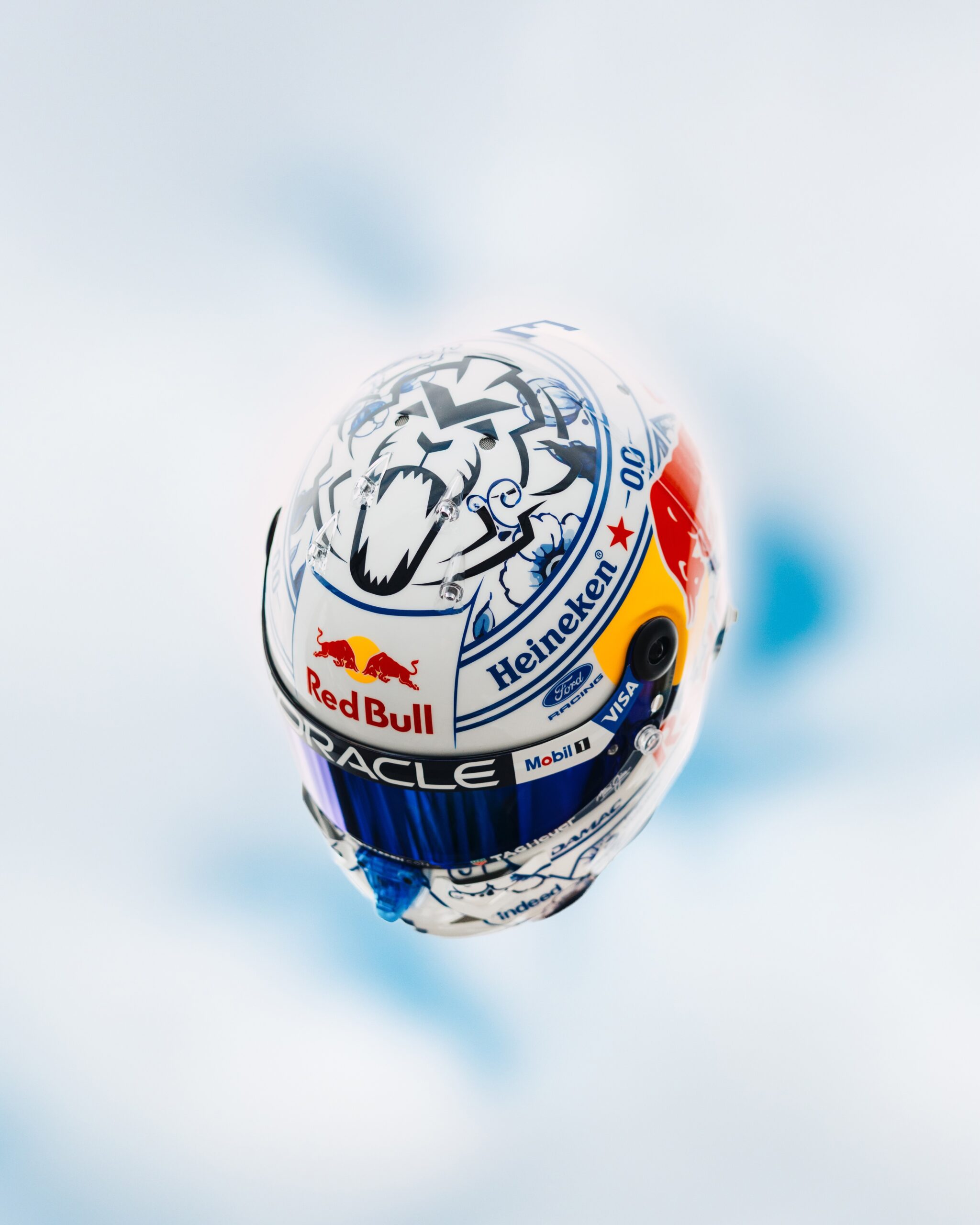 Top-down view of the helmet crown: a Dutch heraldic lion drawn in Delft blue inside a painted ornamental frame.