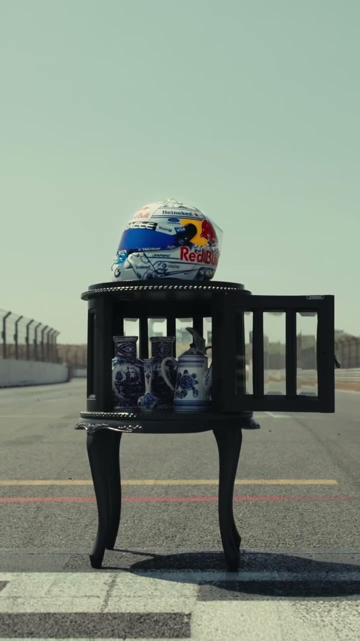 The helmet displayed on a black antique cabinet filled with Delft blue pottery, standing on the Zandvoort pit straight.