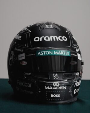 Fernando Alonso's 2026 Spanish GP helmet, front view: matte black shell with white tailoring-pattern linework and a green Aston Martin visor band