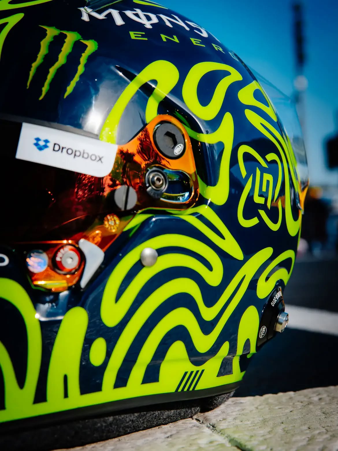 Casco de Lando Norris en Monza 2026: un tributo a Valentino Rossi en remolinos amarillo fluorescente sobre azul marino