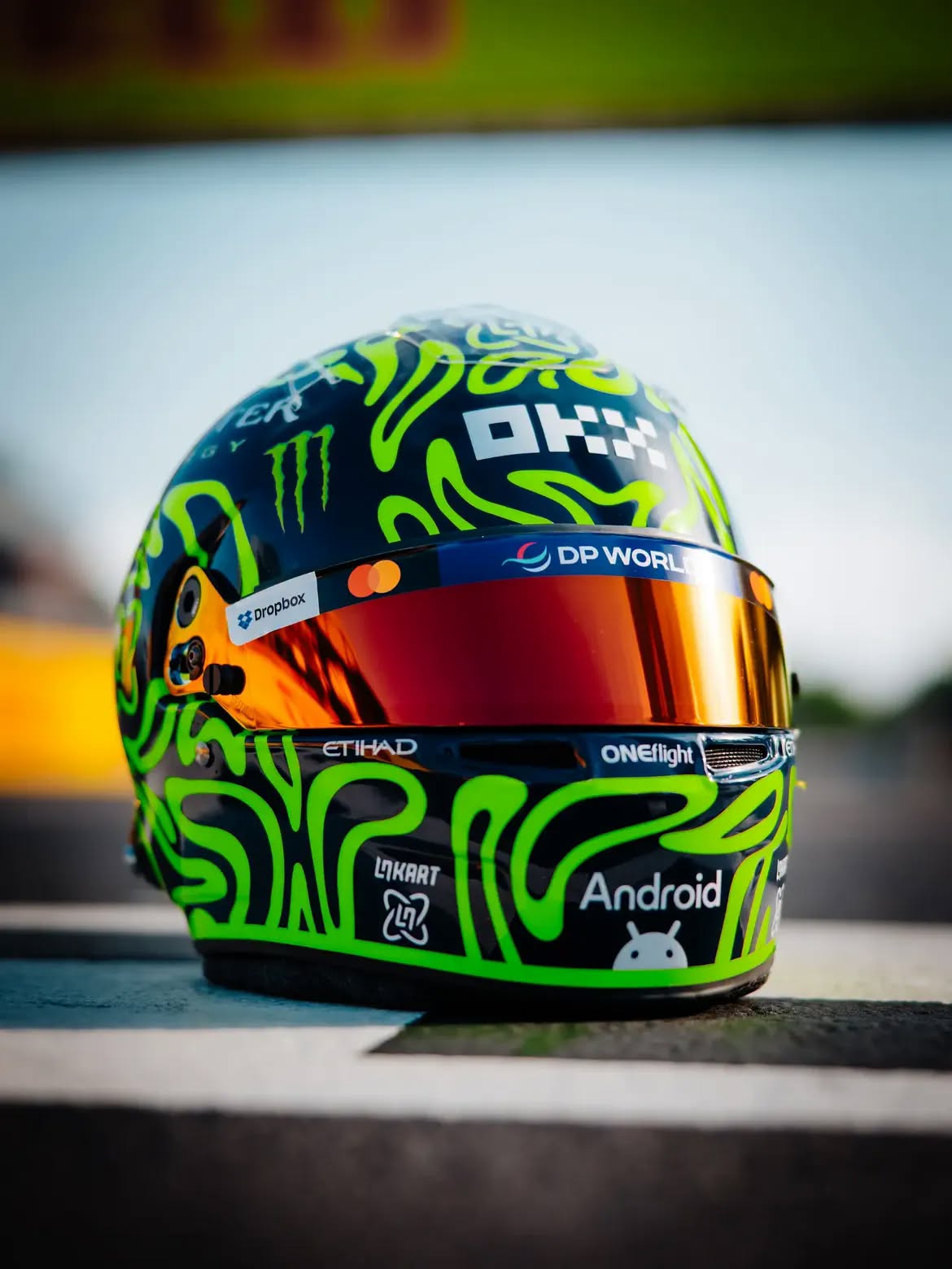 Casco de Lando Norris en Monza 2026: un tributo a Valentino Rossi en remolinos amarillo fluorescente sobre azul marino
