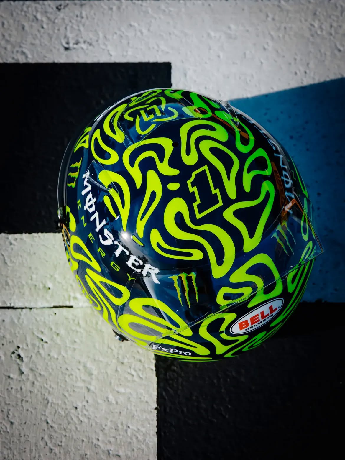 Casco de Lando Norris en Monza 2026: un tributo a Valentino Rossi en remolinos amarillo fluorescente sobre azul marino