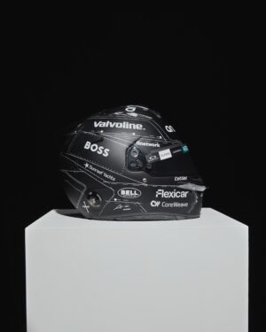 Fernando Alonso's 2026 Spanish GP helmet displayed on a white plinth, matte black with white pattern lines