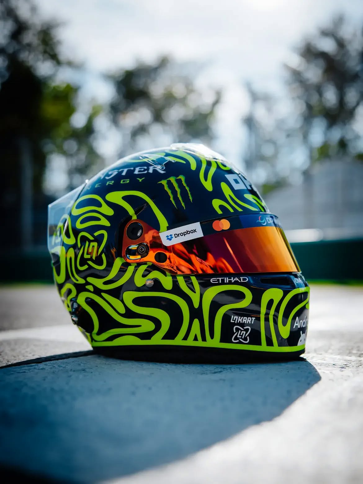 Casco de Lando Norris en Monza 2026: un tributo a Valentino Rossi en remolinos amarillo fluorescente sobre azul marino