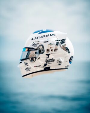 Side view of Alex Albon's white 2026 helmet with chrome panels, Atlassian on the crown and his name with the Thai flag on the lower side