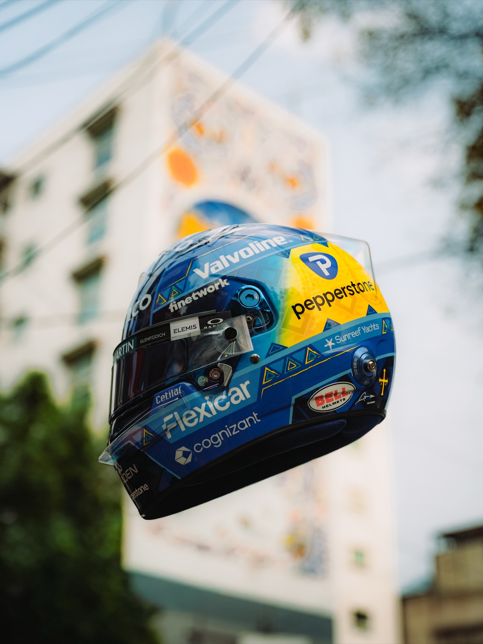 الجانب الأيسر من خوذة Fernando Alonso لجائزة مكسيكو سيتي الكبرى 2026، مع شريط Pepperstone الأصفر وشعاري Flexicar وcognizant، والصليب الأصفر قرب شعار Bell
