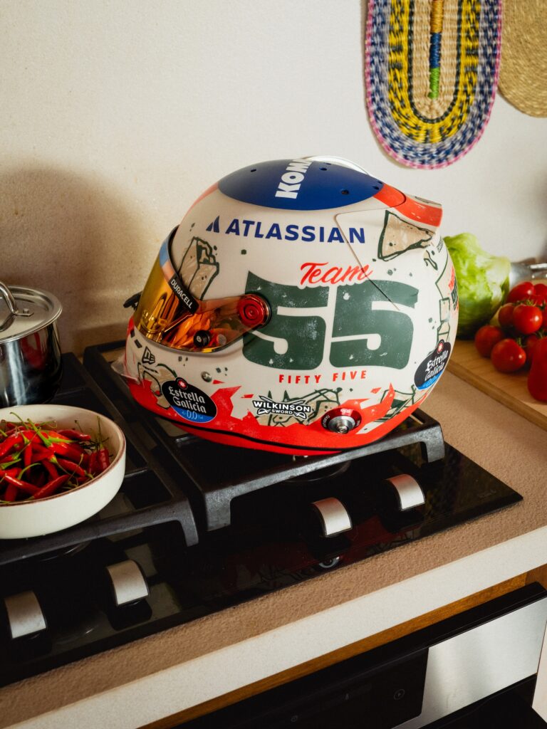 Carlos Sainz's 2026 Mexico City GP helmet on a kitchen stove, with the green 55, Team in red script and FIFTY FIVE