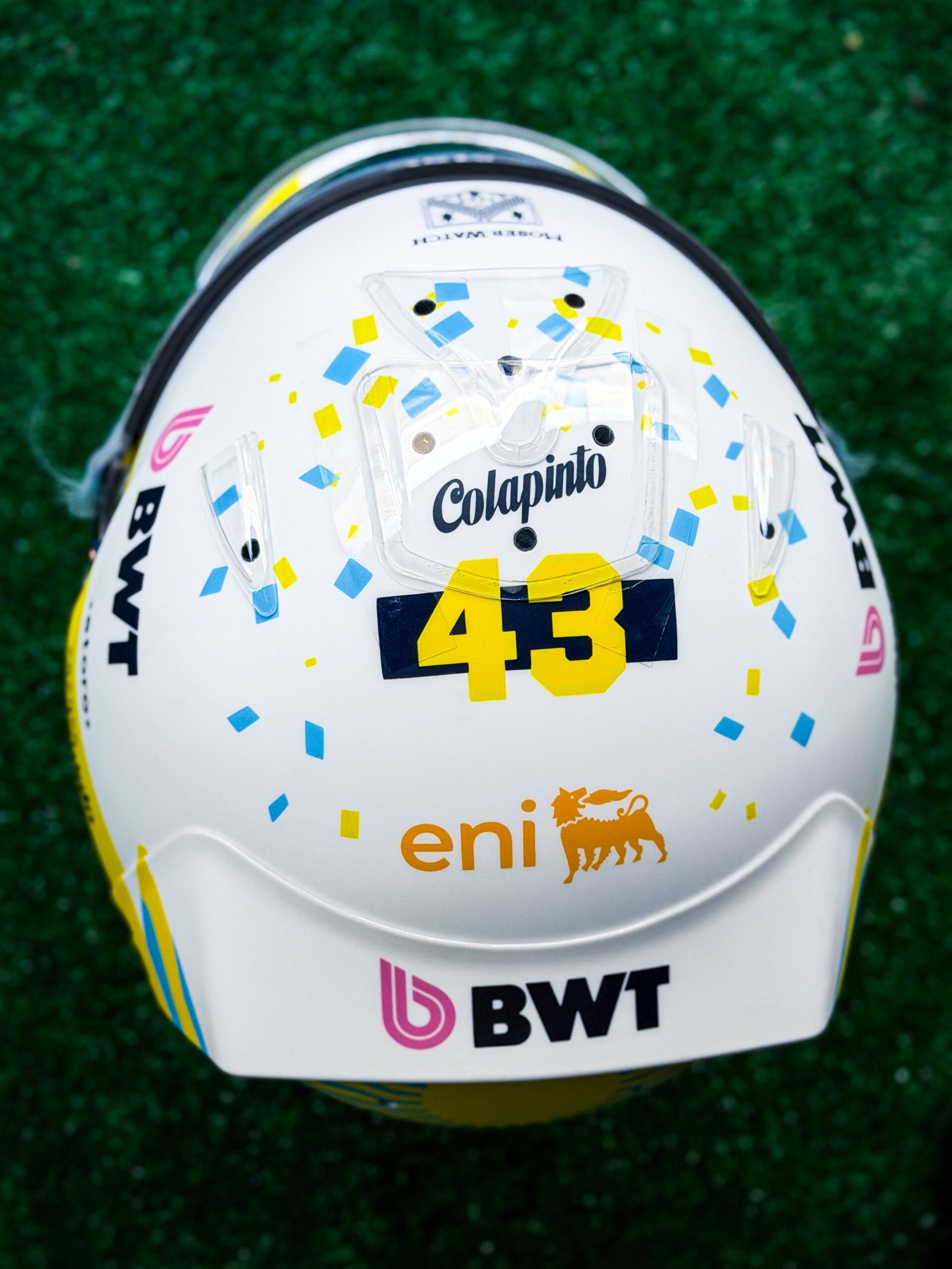 Top of Colapinto's finished Austin 2026 helmet: blue and yellow confetti around Colapinto and 43, eni and BWT at the back