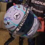 Front view of Kimi Antonelli's 2026 Singapore GP helmet, white base with blue-violet orchids, the Mercedes star and PETRONAS visor strip