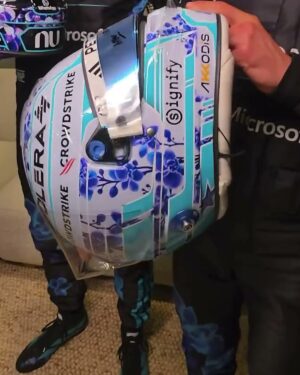 Side view of Kimi Antonelli's 2026 Singapore GP helmet showing orchid branches, turquoise stripes and Signify and Akkodis logos