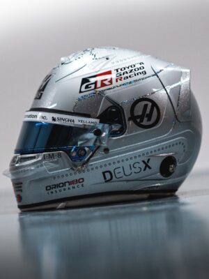 Side view of Oliver Bearman's 2026 Singapore GP helmet, glitter silver with holographic lines, Toyota Gazoo Racing and Haas logos