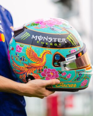 Side view of Oscar Piastri's 2026 Singapore GP helmet: turquoise beadwork, red and gold phoenix, pink peonies and Oscar in gold